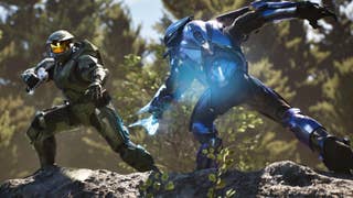Master Chief fighting an alien enemy stood on some rocks in a forest.